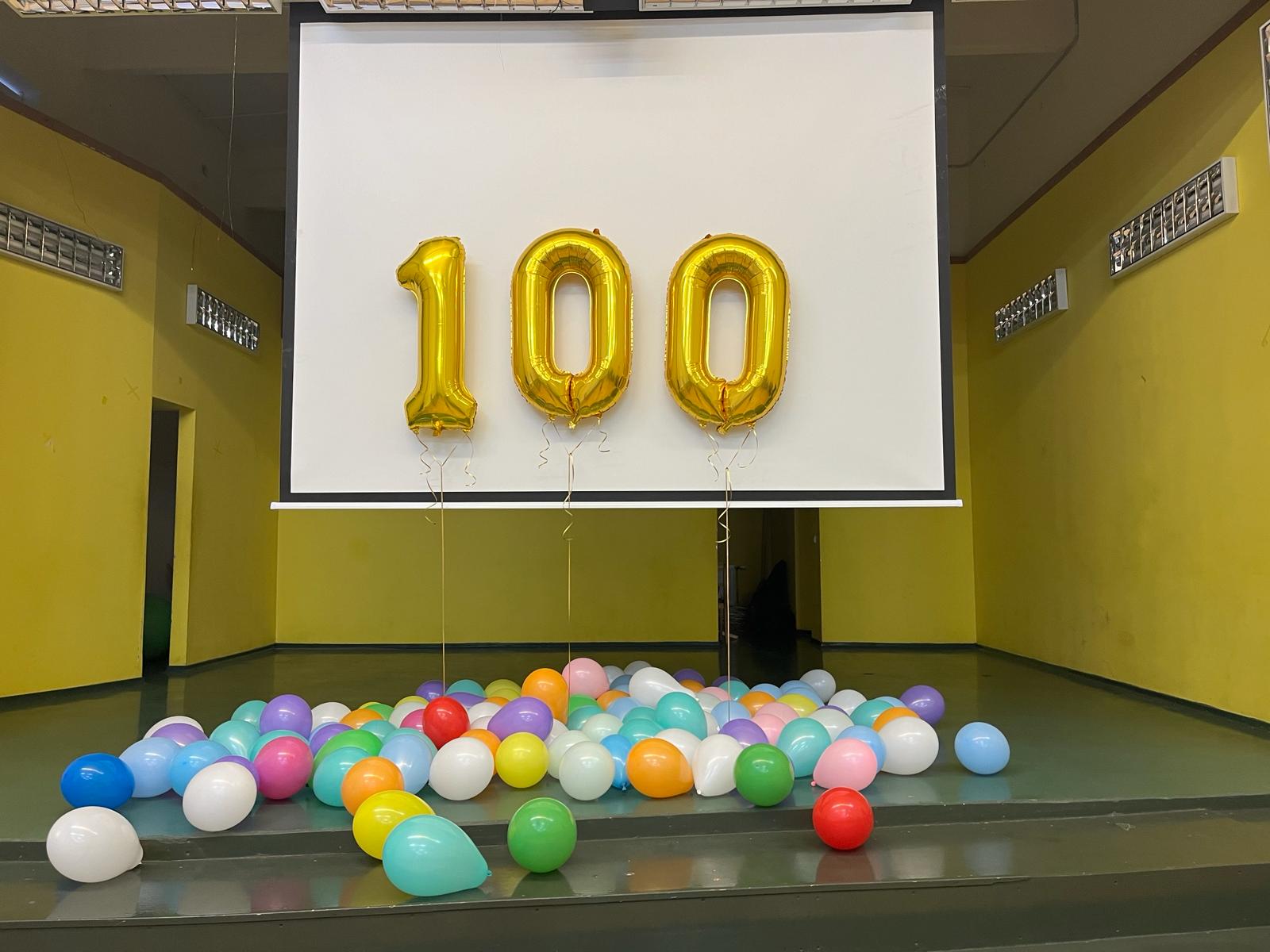 zelta krāsā baloni- cipars 100. Uz zemes krāsaini baloni