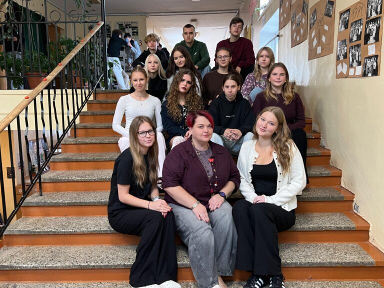 Pašpārvaldes skolēni un skolotāja izvietojušies uz kāpnēm skolas foajē.